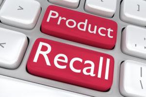 Close-up of a computer keyboard with two red keys labeled "Product" and "Recall," highlighting the urgency of a defective product notice. These keys stand in stark contrast against the surrounding white keys, emphasizing the critical nature of the message.