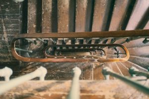 A bird's-eye view of a spiral staircase in Washington D.C. reveals a wooden handrail and metal balusters, crafting a visually striking pattern as it descends. The worn steps tell stories of history, adding character to the mesmerizing image.
