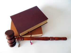 A judge's gavel lies beside two stacked law books with brown covers on a white surface, reflecting the ongoing focus on safety regulations in Washington D.C. following recent subway accidents.