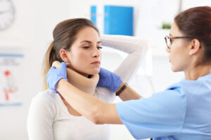 woman getting her neck brace put on by a doctor
