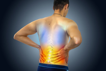 A person shown from behind holds their lower back in pain. The spine is highlighted, with colored gradients from blue to red, illustrating discomfort or inflammation—potentially related to chronic pain compensation issues in Washington D.C.